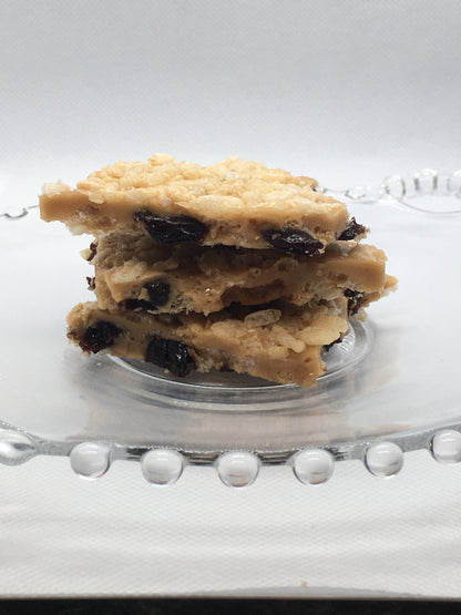 A picture of toffee with rice crispies and dried cherries on a decorative glass plate.