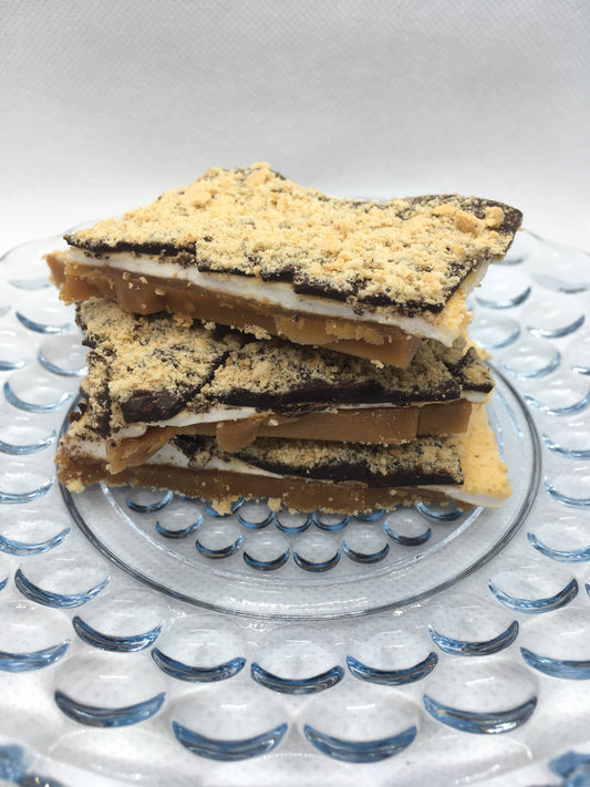 Toffee layered with marshmallow, chocolate and graham cracker crumbs on a decorative glass plate.